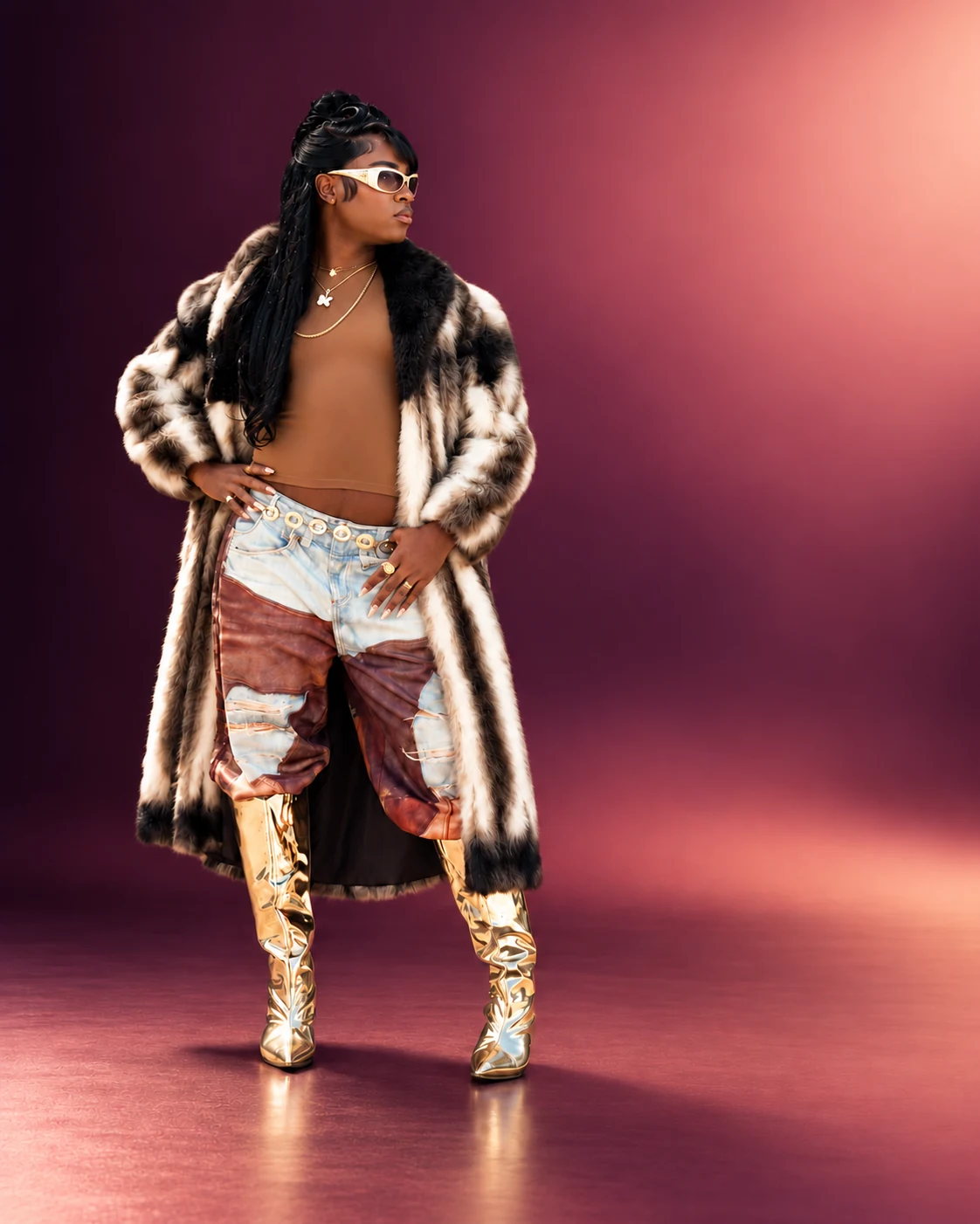 Lo-Key in a fur coat, statement trousers and metallic gold boots, standing against a plum ombré backdrop